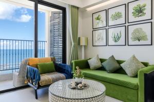 a living room with a green couch and a table at Rosie Hillside Seaview Phu Quoc Apartment in Phu Quoc
