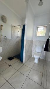ein weißes Badezimmer mit Toilette und Dusche in der Unterkunft Accom KC's in Airlie Beach + 2 Fotos
