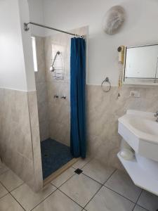 ein Badezimmer mit einer Dusche mit einem blauen Duschvorhang in der Unterkunft Accom KC's in Airlie Beach