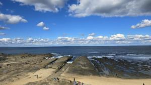 a group of people standing on a beach near the ocean at Coastal Hideaway By Lake in Toukley