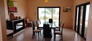 a dining room with a black table and chairs at Villas Vetiver in Rodrigues Island