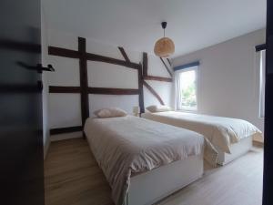 ein Schlafzimmer mit zwei Betten und einem Fenster in der Unterkunft Au ptit Hottonruy in Stavelot
