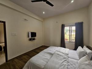 una camera da letto con un letto e una TV a parete di The Nest a Bhubaneshwar