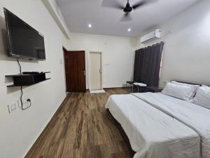 una camera da letto con un letto e una TV a schermo piatto di The Nest a Bhubaneshwar