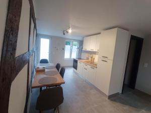 eine Küche mit einem Tisch und einem weißen Kühlschrank in der Unterkunft Au ptit Hottonruy in Stavelot