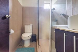 a bathroom with a toilet and a glass shower at Condo Playa Hermosa, Puntarenas in Muñeco +58 photos