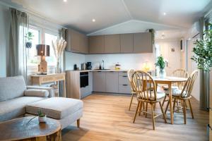 a kitchen and living room with a table and chairs at Ferienhaus Landliebe Lodges in Falkenthal