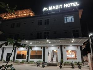 a hotel with motorcycles parked outside of it at night at Mabit Hotel Syariah in Takengon