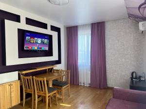 a living room with a table and a tv at Готельний комплекс in Babachikha