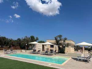une piscine avec chaises longues et parasols dans l'établissement Villa Lara - mit separatem extra Zimmer mit Wc und Dusche, à San Vito dei Normanni