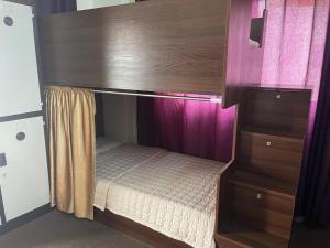 een hemelbed in een kamer met paarse gordijnen bij Pizza Street Hostel in Aqaba