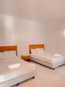 two beds sitting next to each other in a room at Tekoma Resort Taman Negara in Kuala Tahan