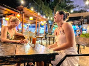 two women sitting at a table in a restaurant at Gili Beach Bum Hostel in Gili Trawangan