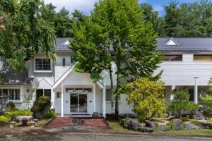 富士吉田市にあるFujiyama Inn Coniferの前庭の木のある白い家