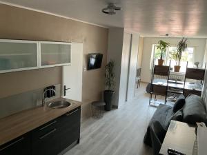a kitchen and living room with a couch and a table at Studio Moderne - Parking - Proche Luxembourg et CNPE in Basse-Ham
