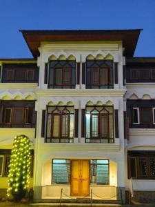 a white building with a christmas tree in front of it at Silk Route in Srinagar