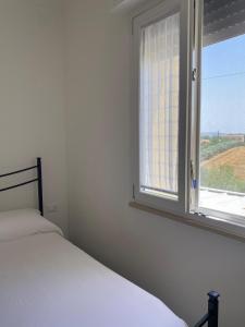 a white bedroom with a bed and a window at Villa Cecilia in Scerni +23 photos