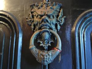 a metal door knocker with a skull on it at The Covenstead in Glastonbury