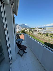 a balcony with two chairs and a table on it at Le Beauvert 2 NOUVEAU à GRENOBLE parking gratuit in Grenoble