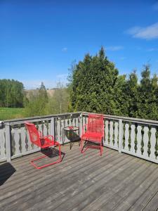 two red chairs and a table on a deck at Rooms with free parking in Lillestrøm