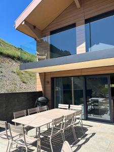 a table and chairs on the patio of a house at Chalets Horizon Blanc - Vue exceptionnelle -Sauna extérieur -5 étoiles in Les Deux Alpes