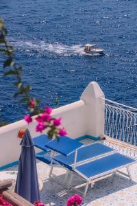 a couple of chairs and a boat in the water at Hotel Costa Diva in Praiano