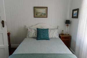 Gracie Cottage Romantic Secluded Hinterland Escape for 2 في مابيلتون: سرير مع وسائد زرقاء في غرفة النوم