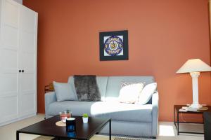 a living room with a blue couch and an orange wall at T1 Augustin in Gradignan