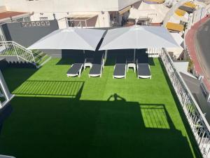 an umbrella and chairs on the roof of a building at Villa Amir in Fuengirola
