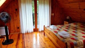 a bedroom with a bed with a fan and a window at Chata na Jurze z balią in Zarki Letnisko +28 photos