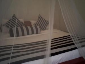a bed with striped pillows and a canopy at Sunburst view in Ella