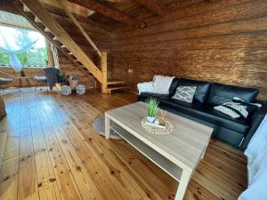 a living room with a black couch and a table at Brīvdienu māja Straumēni in Pāle