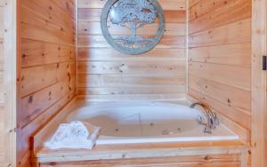 a bathroom with a tub in a wooden wall at Ever After Gatlinburg in Gatlinburg +24 photos