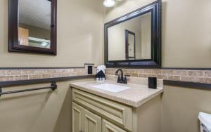 セバービルにあるMountain Dreams 1430 Hot Tub Fire Pit Arcade Gameの洗面台と2つの鏡があるバスルーム +17枚の写真
