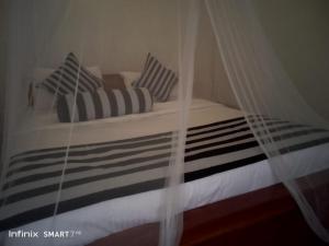 a bed with black and white pillows and a curtain at Sunburst view in Ella
