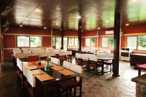 a dining room with tables and chairs in a restaurant at Wild Adventure Resort in Sauraha