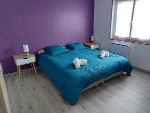 a bedroom with a blue bed with towels on it at Entre Tours et Loches in Tauxigny