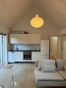 a living room with a couch and a kitchen at Gästhus Abbekås in Abbekås +8 photos