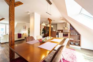 a dining room and living room with a wooden table and chairs at Grand Superior - Viel Platz mitten im Ort in Bad Zwischenahn +18 photos