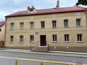 a large tan building with a red roof at Apartament Górna in Gołdap