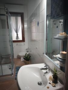 a white bathroom with a sink and a shower at Casa vacanza Muravera "House Gardens" in Muravera