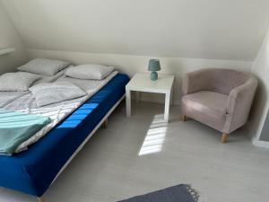 a bedroom with a bed and a chair and a table at Pokoje z łazienką przy Porcie Genaker w Giżycku in Giżycko