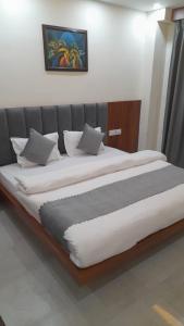 una cama grande con sábanas y almohadas blancas en Groves, en Ranchi 6 fotos más