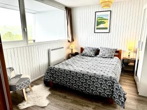 sypialnia z łóżkiem i oknem w obiekcie Appartement cosy Centre station de Super Besse pour 2 à 6 personnes w mieście Besse-et-Saint-Anastaise