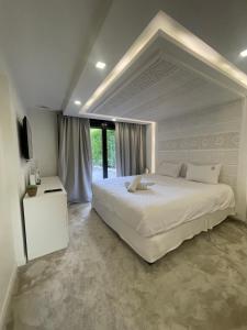 une chambre avec un grand lit blanc et une télévision dans l'établissement Villa avec piscine 35 min de Paris, à Étiolles 31 autres photos