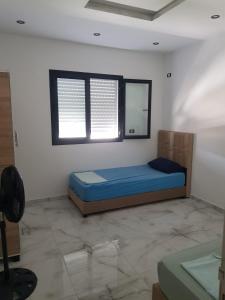 een slaapkamer met een bed en een raam in een kamer bij Villa Kenza in Douar el Khima