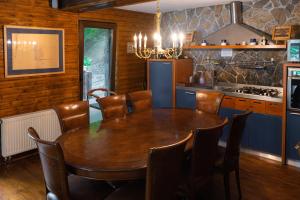 a dining room with a table and a kitchen at Pensiunea Lac in Arefu