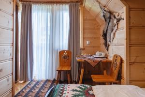 a bedroom with a bed and a table and chairs at Willa Szafran - pokoje in Zakopane
