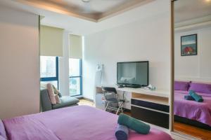 a bedroom with a bed and a desk with a tv at Couple Suite at Casa Residency 5 mins walk to LRT, Jalan Alor & Bukit Bintang in Kuala Lumpur