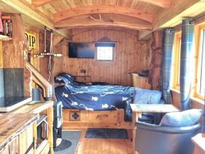 a small bedroom with a bed in a cabin at The Shepherds Neuk in Inverness